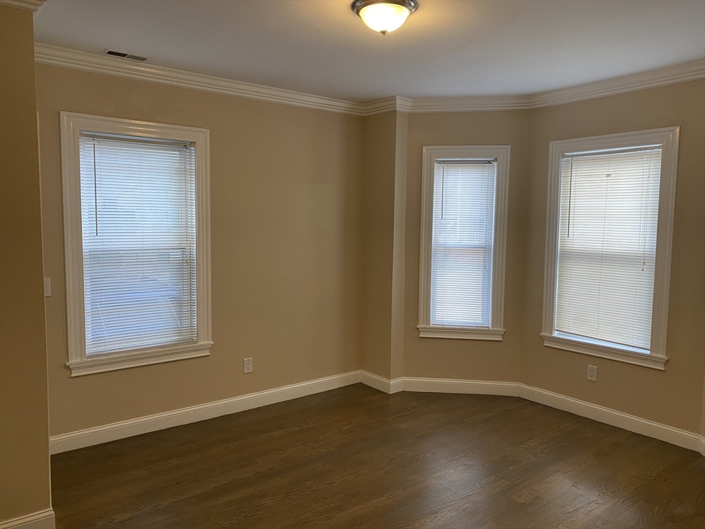 8 Buckley Avenue, Unit 2 Boston, MA 02130 - Photo 3 of 8 an empty room with wooden floor and windows