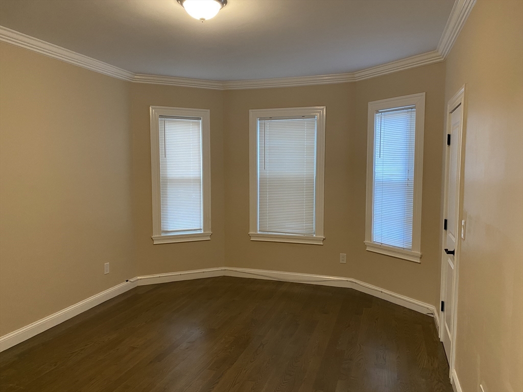 8 Buckley Avenue, Unit 2 Boston, MA 02130 - Photo 5 of 8 a view of an empty room with wooden floor and a window