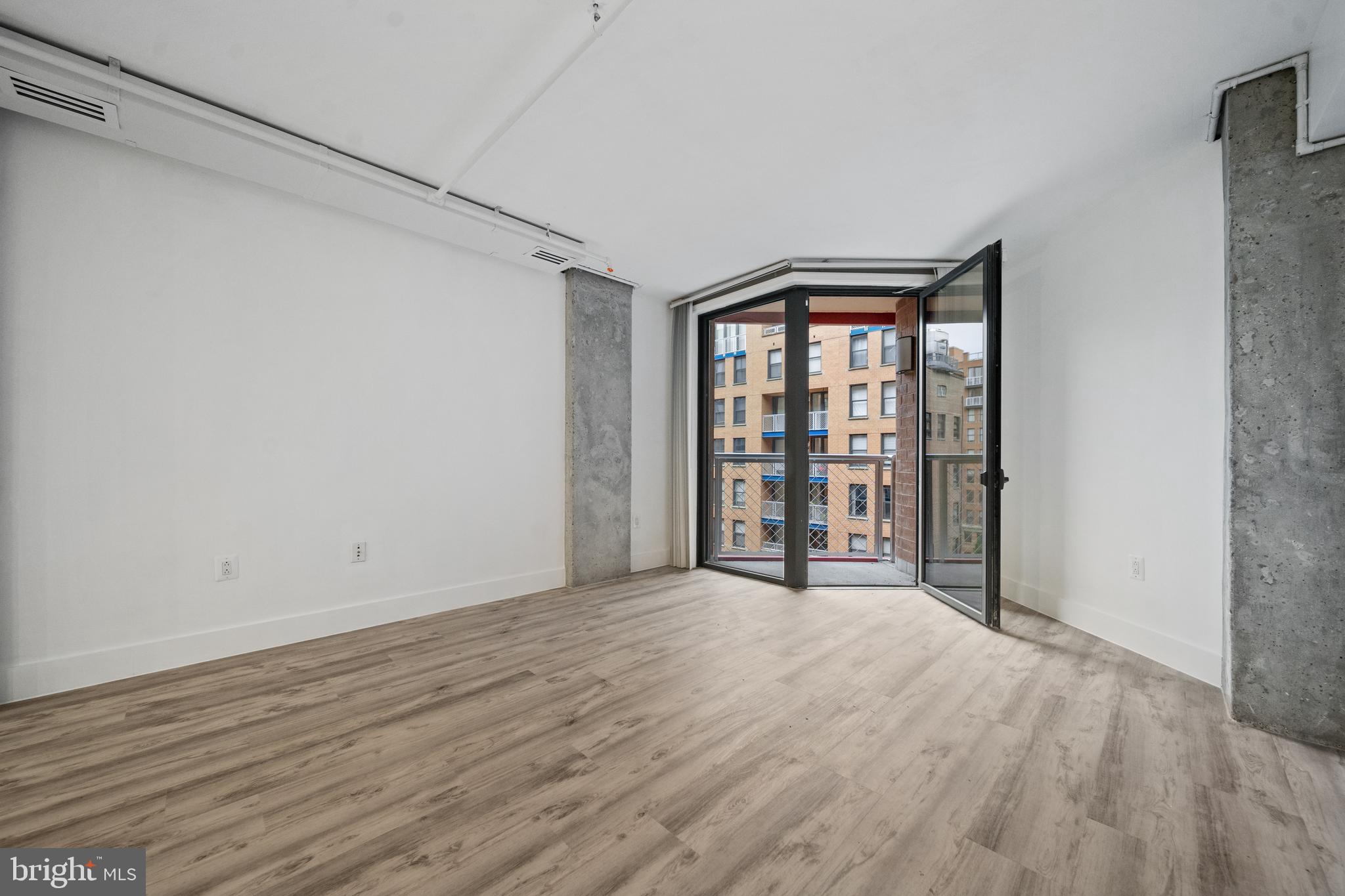 616 E Street Northwest, Unit 856 Washington, DC 20004 - Photo 13 of 84 a view of an empty room with wooden floor and a window