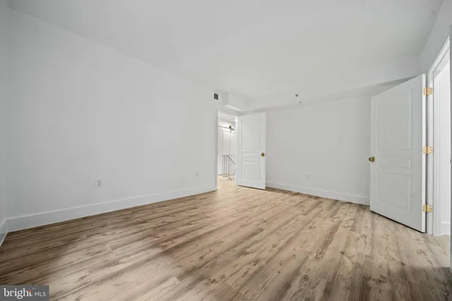 a view of an empty room with wooden floor