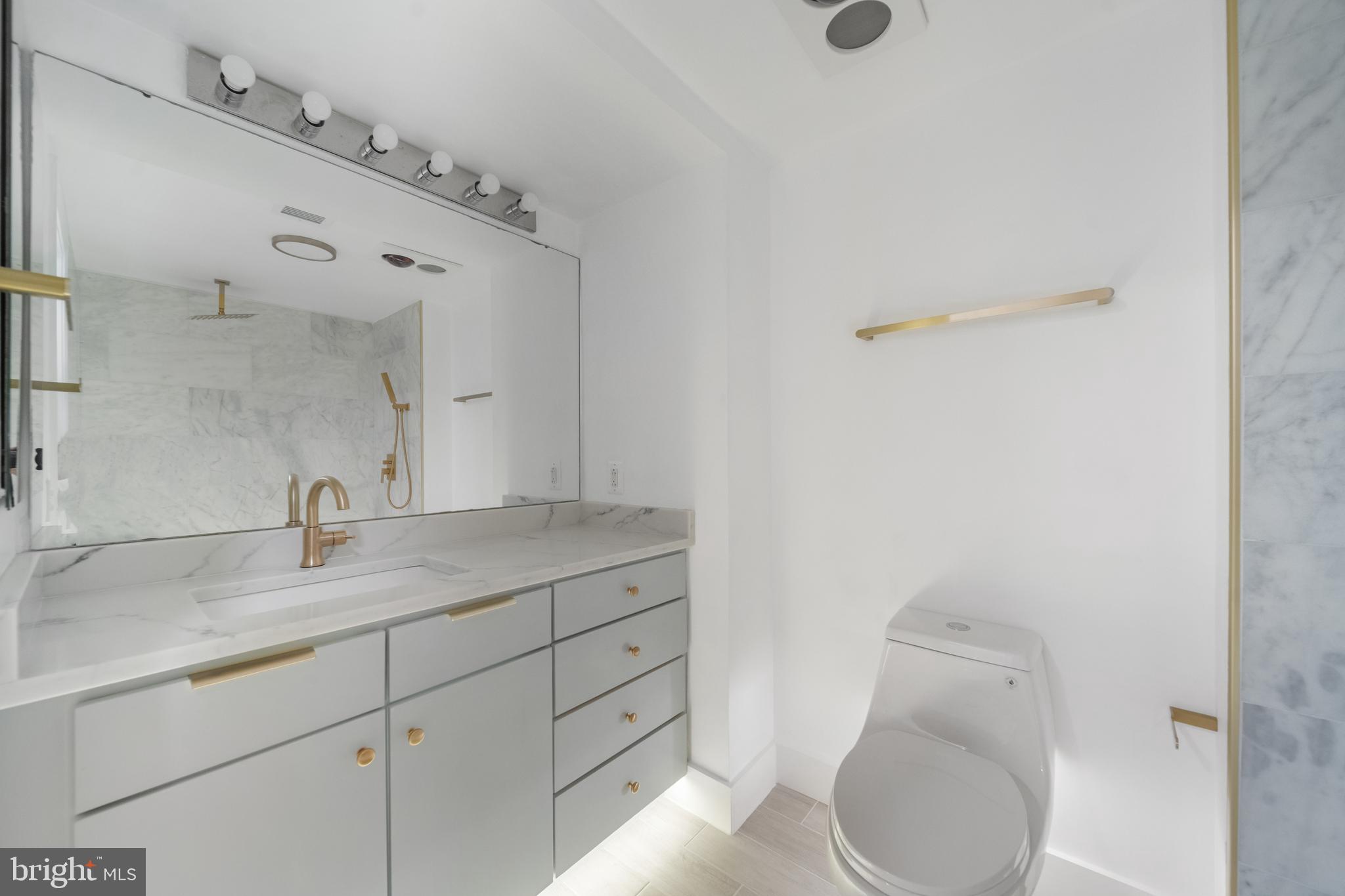 616 E Street Northwest, Unit 856 Washington, DC 20004 - Photo 35 of 84 a bathroom with a granite countertop sink a toilet and a mirror