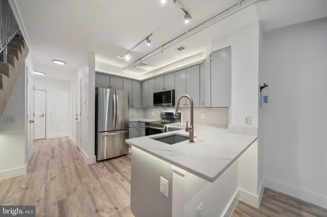 a kitchen with stainless steel appliances a stove a sink and a refrigerator
