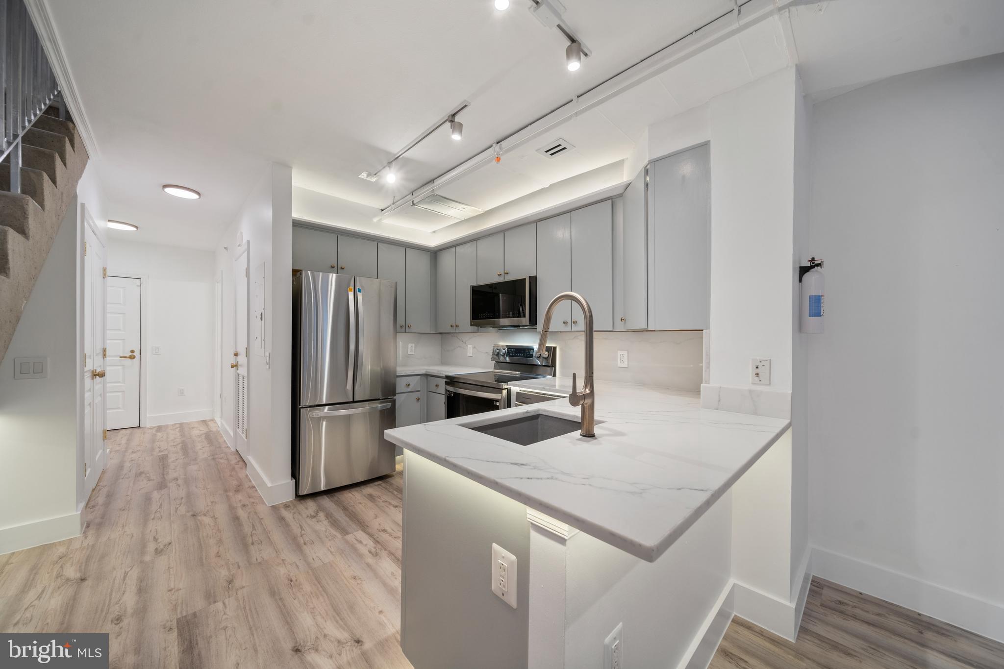616 E Street Northwest, Unit 856 Washington, DC 20004 - Photo 4 of 84 a kitchen with a sink a counter top space stainless steel appliances and cabinets