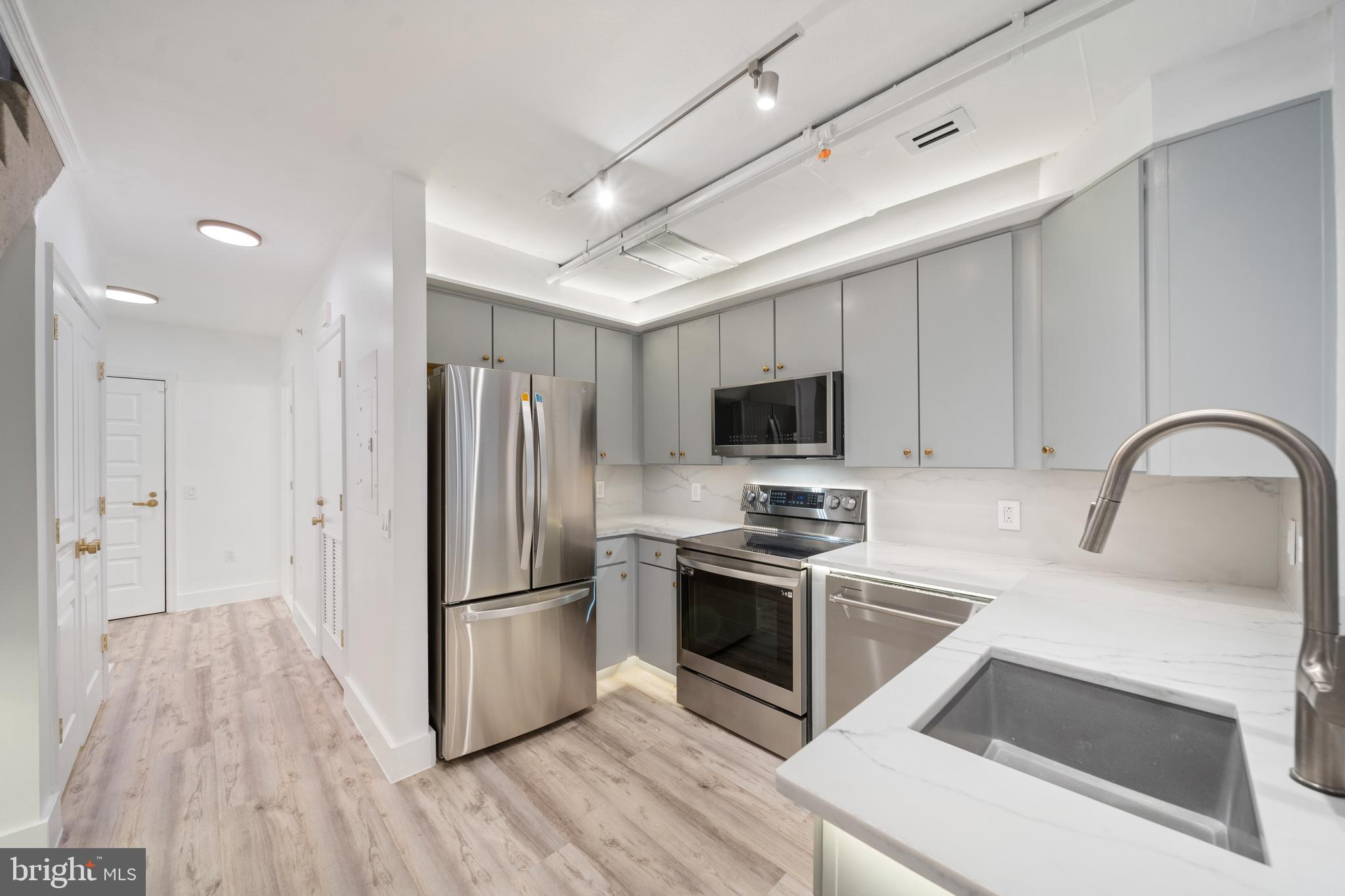 616 E Street Northwest, Unit 856 Washington, DC 20004 - Photo 5 of 84 a kitchen with stainless steel appliances a stove a sink and a refrigerator
