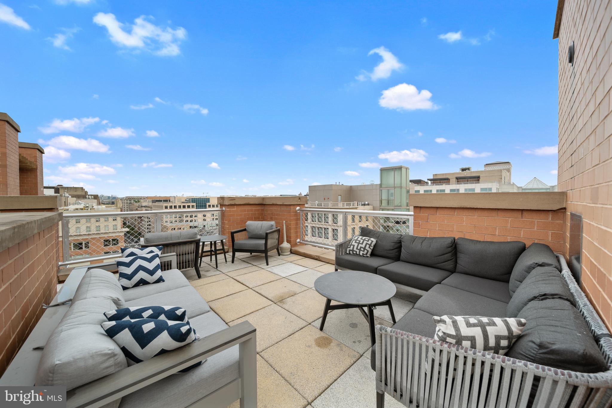 616 E Street Northwest, Unit 856 Washington, DC 20004 - Photo 60 of 84 a roof deck with couches and potted plants with sky view