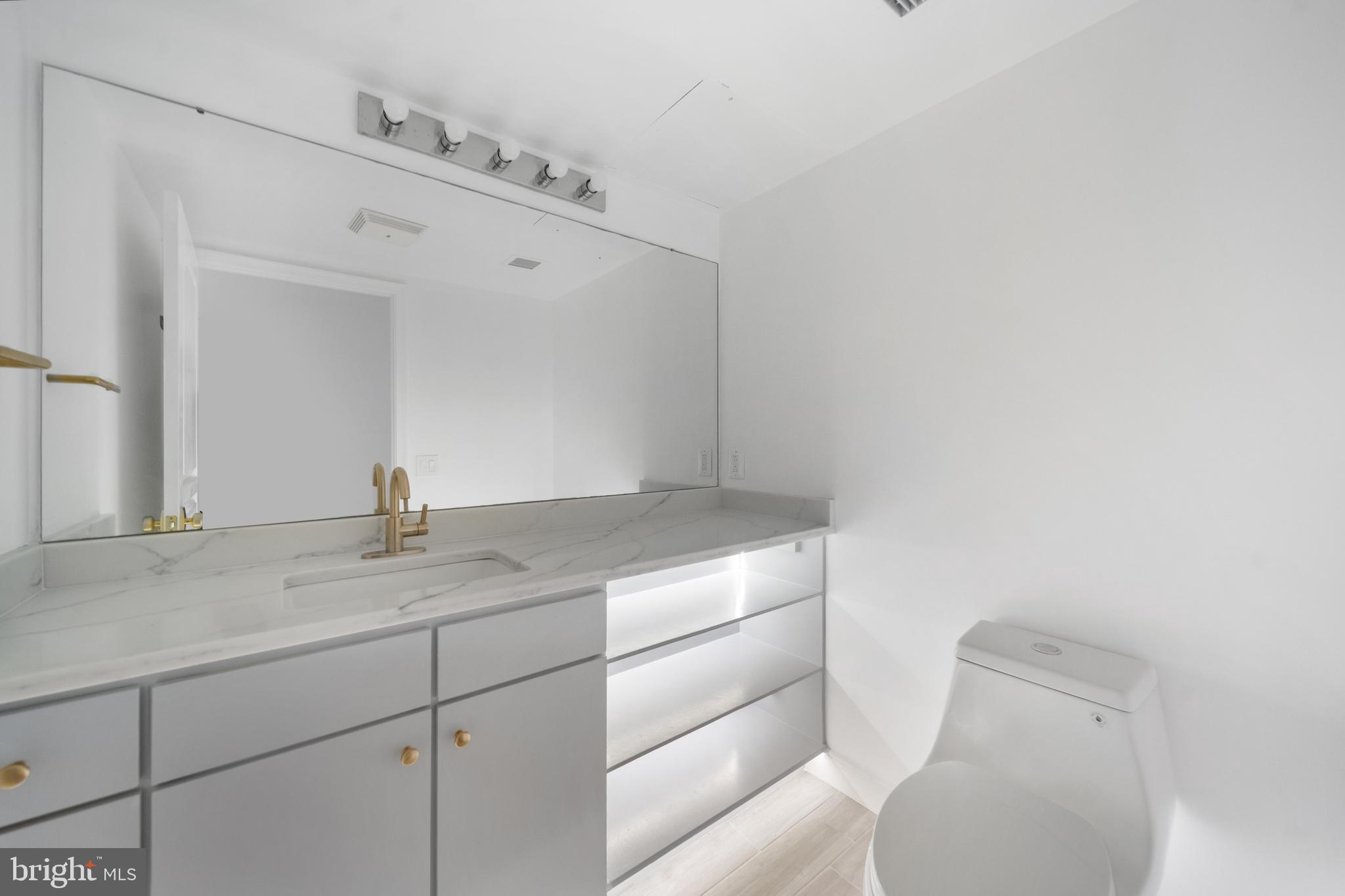 616 E Street Northwest, Unit 856 Washington, DC 20004 - Photo 8 of 84 a bathroom with a granite countertop sink and a mirror