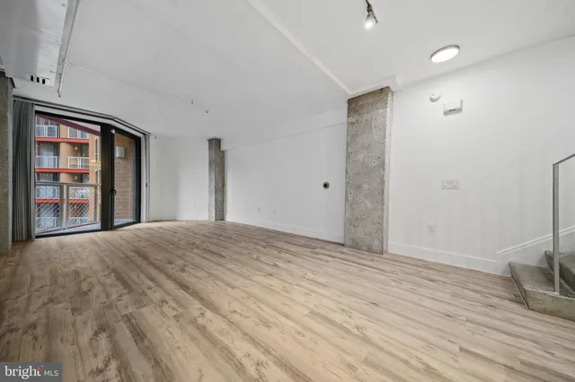 a view of a room with wooden floor and a ceiling fan