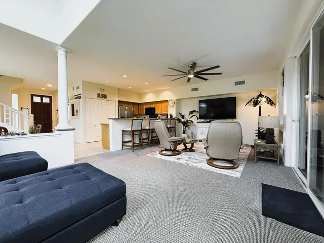 a living room with furniture a flat screen tv and a large window