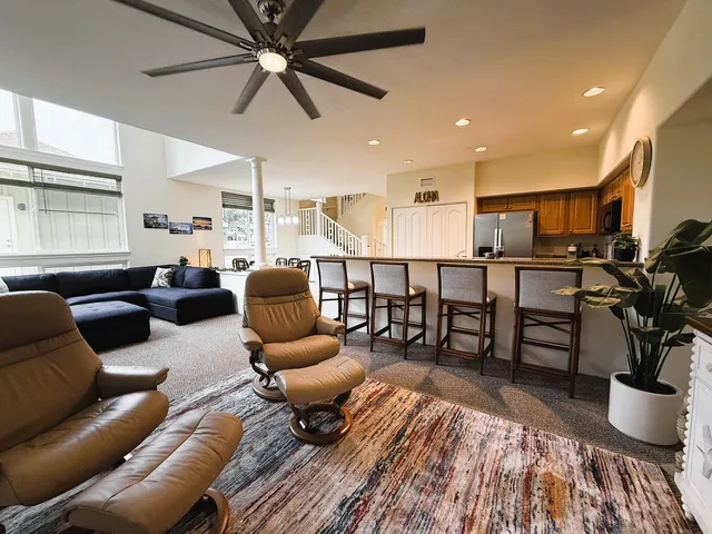 a living room with furniture and a dining table with wooden floor
