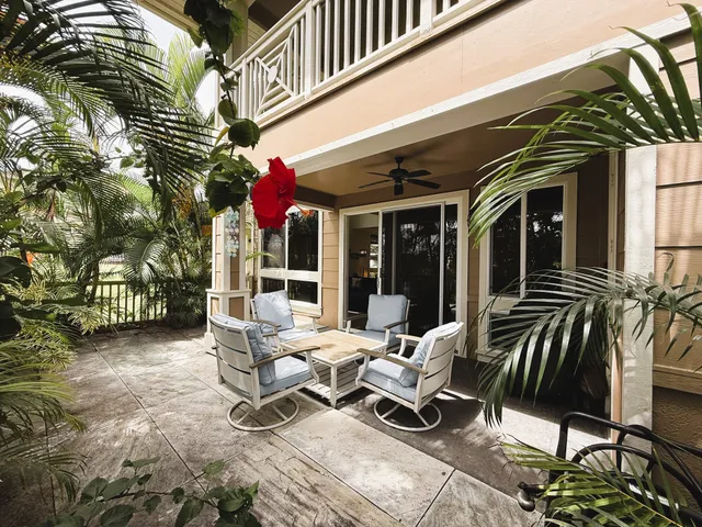 a view of a patio with couches table and chairs and potted plants