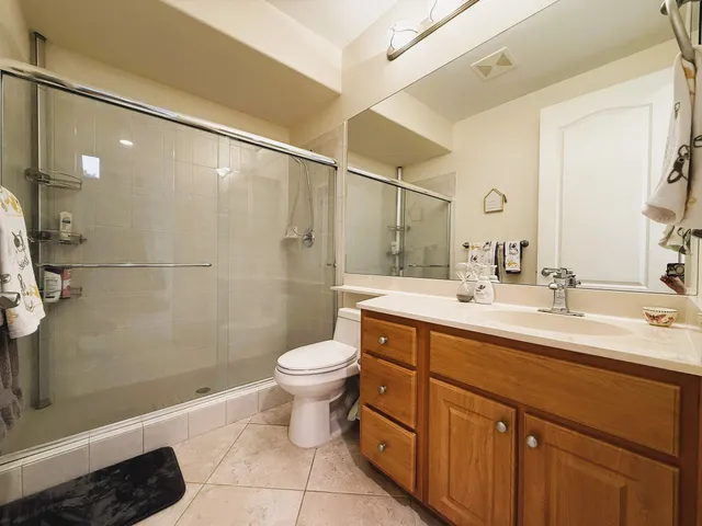 a bathroom with a double vanity sink toilet and shower