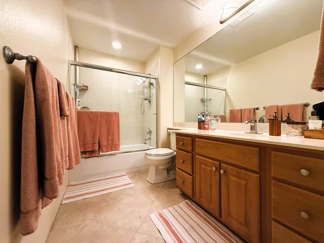 a bathroom with a double vanity sink toilet mirror and shower