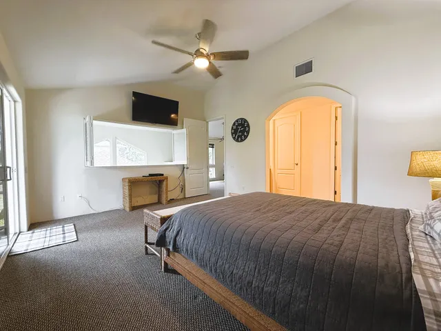 a bedroom with a bed a fireplace and a flat tv screen