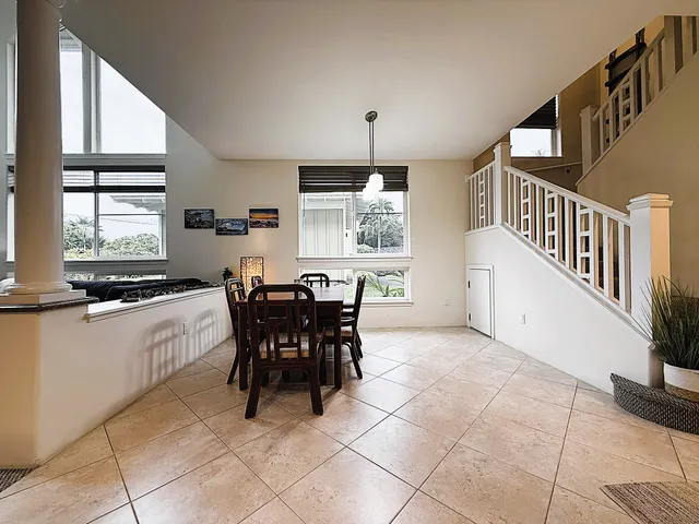 a kitchen with stainless steel appliances a dining table chairs and windows
