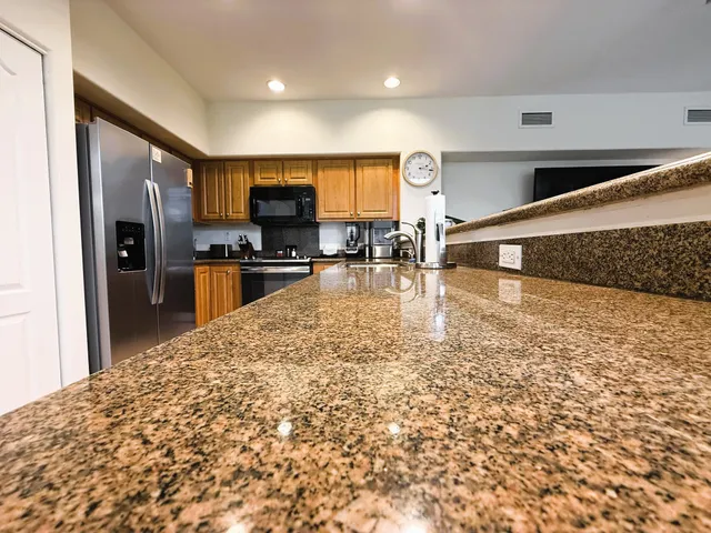 a large kitchen with cabinets in it and stainless steel appliances