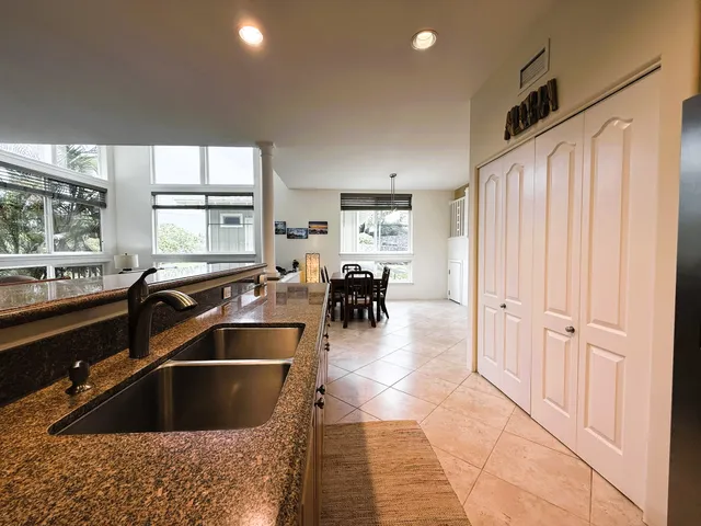 a kitchen with granite countertop a sink and a refrigerator