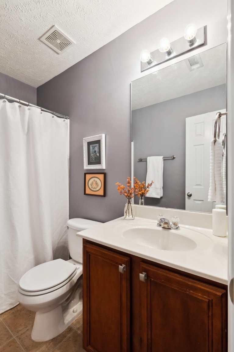 8338 Rossi Road Brentwood, TN 37027 - Photo 14 of 16 a bathroom with a sink a toilet a mirror a vanity and shower