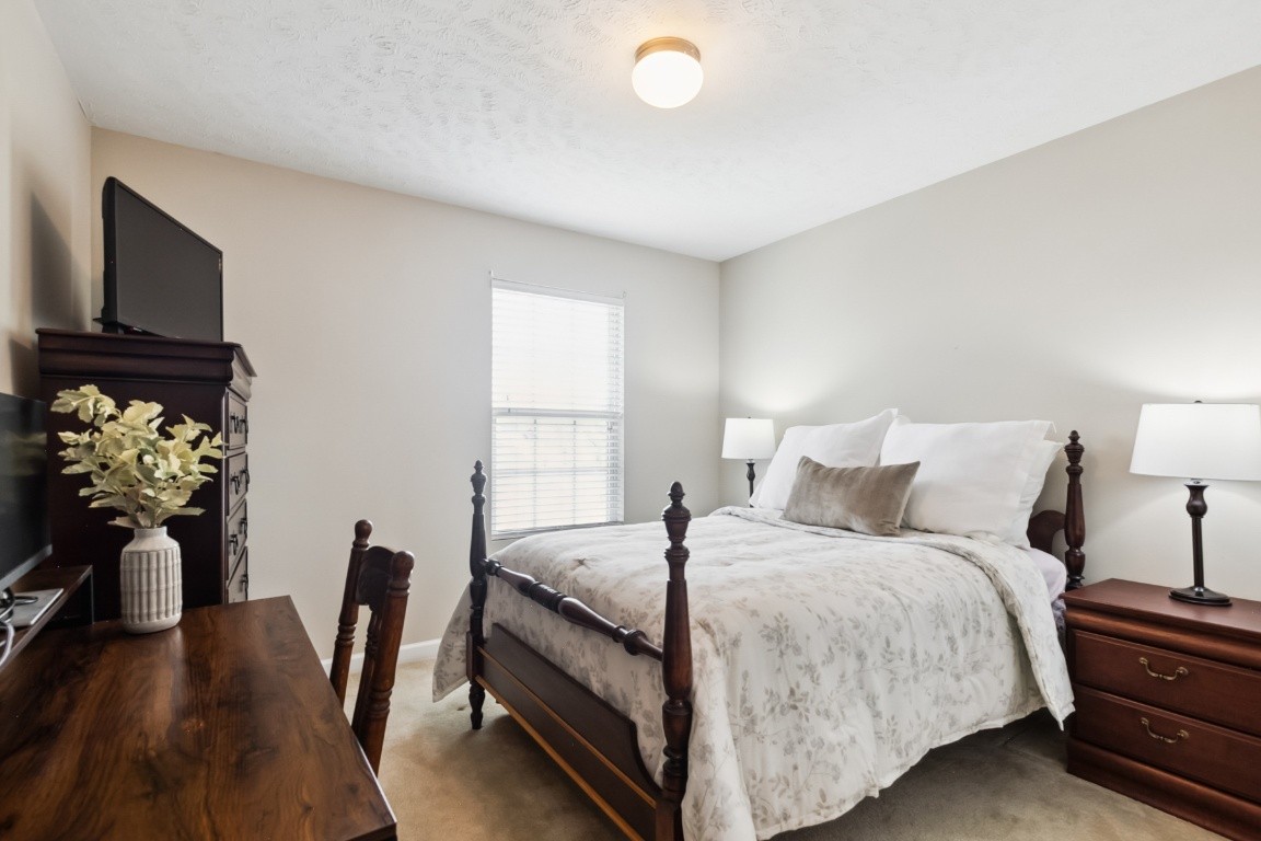 8338 Rossi Road Brentwood, TN 37027 - Photo 15 of 16 a bedroom with a bed table and a flat screen tv