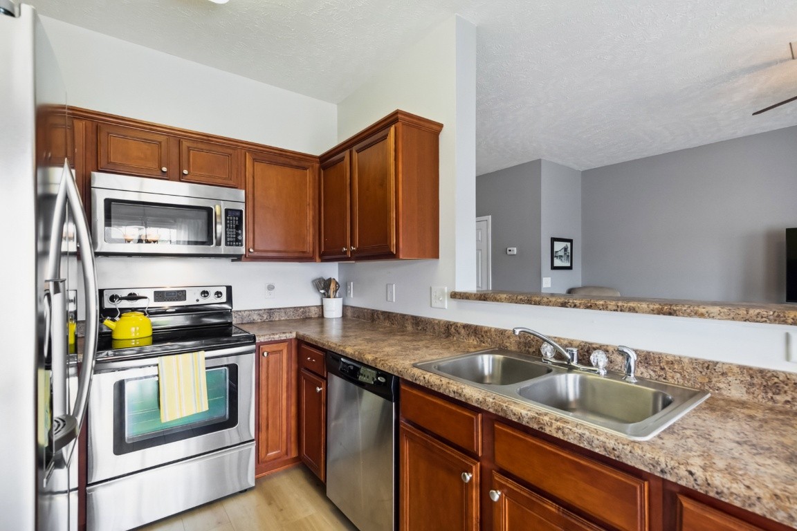 8338 Rossi Road Brentwood, TN 37027 - Photo 6 of 16 a kitchen with granite countertop a sink and stove top oven