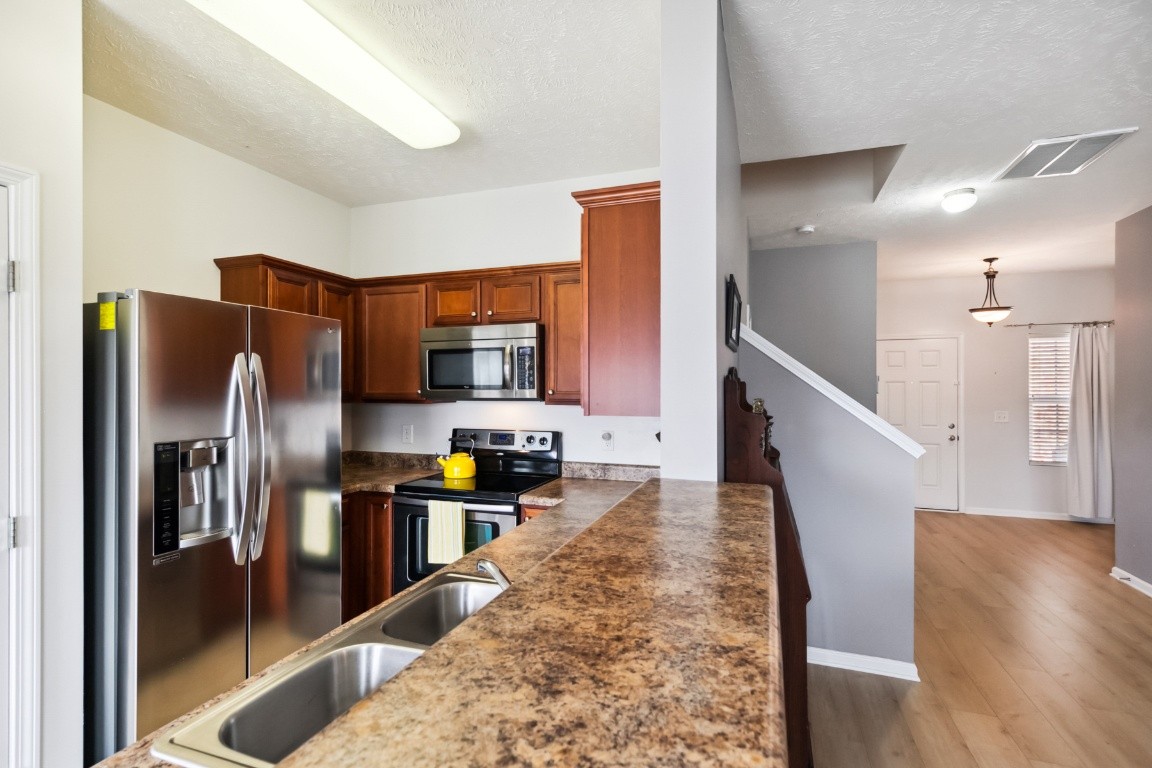 8338 Rossi Road Brentwood, TN 37027 - Photo 7 of 16 a kitchen with stainless steel appliances granite countertop a refrigerator and a stove