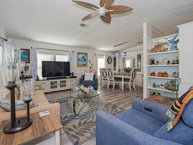 a living room with furniture ceiling fan and a window