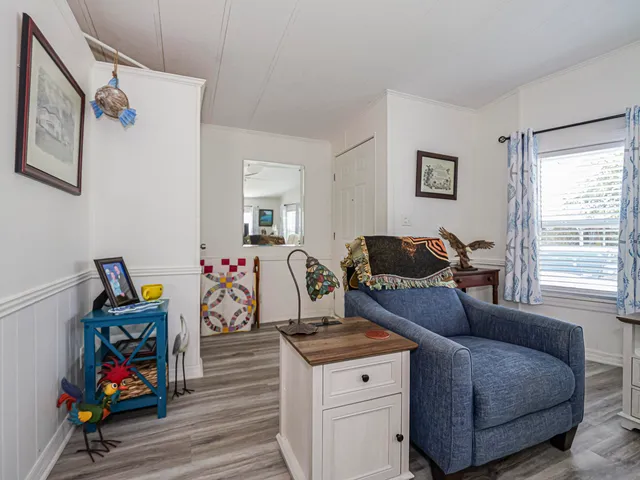 a kitchen with stainless steel appliances kitchen island granite countertop a refrigerator a stove top oven a sink dishwasher and a dining table with wooden floor