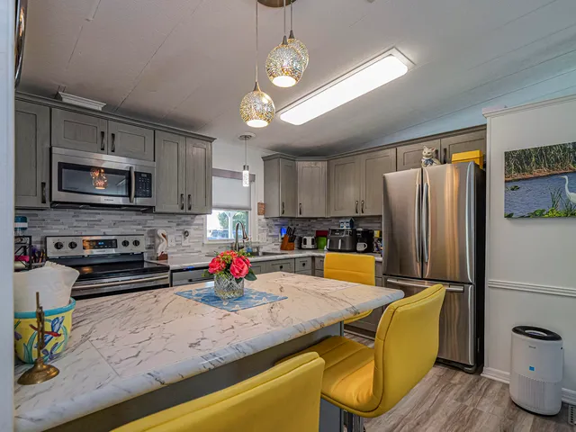 a kitchen with white cabinets sink and stainless steel appliances