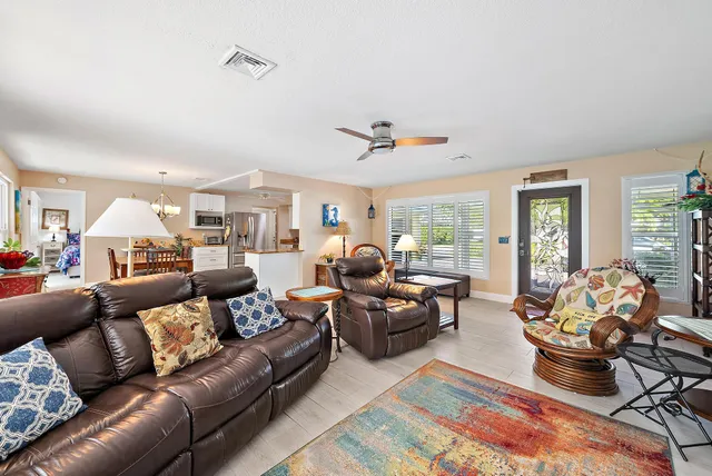 a living room with furniture kitchen view and large windows