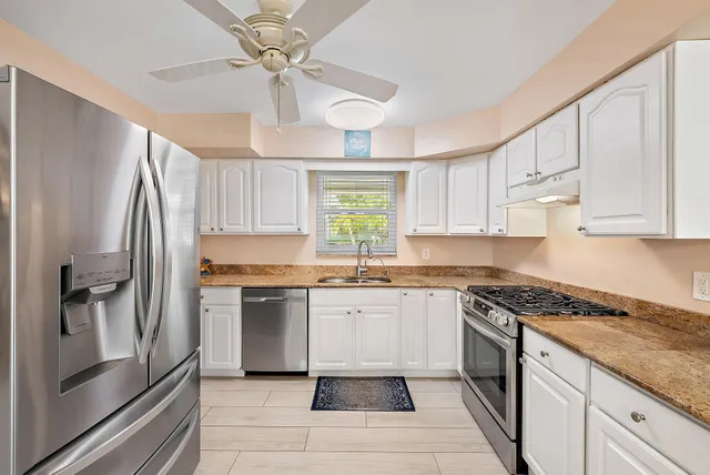 a kitchen with stainless steel appliances granite countertop a stove a refrigerator and a sink