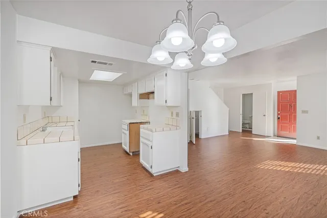 a view of a kitchen with a sink dishwasher and wooden floor