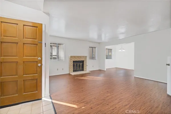 an empty room with windows and fireplace
