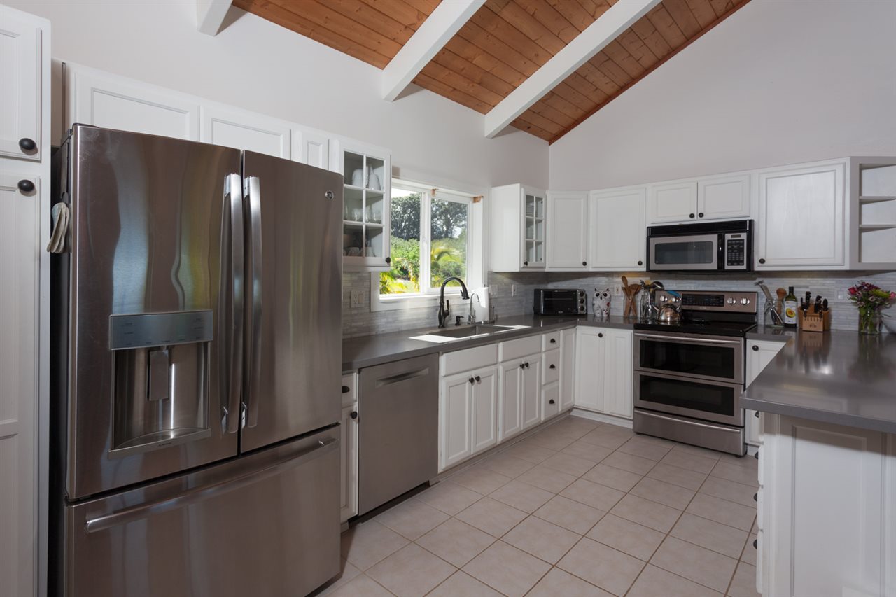 53 Awalau Road Haiku, HI 96708 - Photo 21 of 30 a kitchen with stainless steel appliances granite countertop a refrigerator a stove top oven a sink and dishwasher