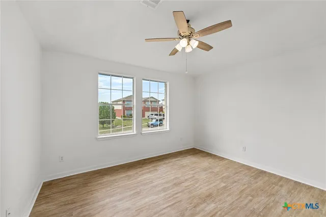 wooden floor in an empty room with a window