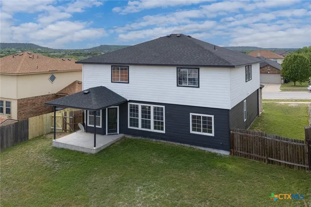 a view of backyard with tub and wooden fence