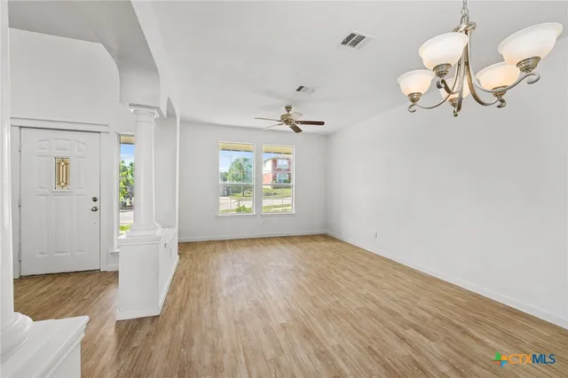 a view of a room with wooden floor and white walls