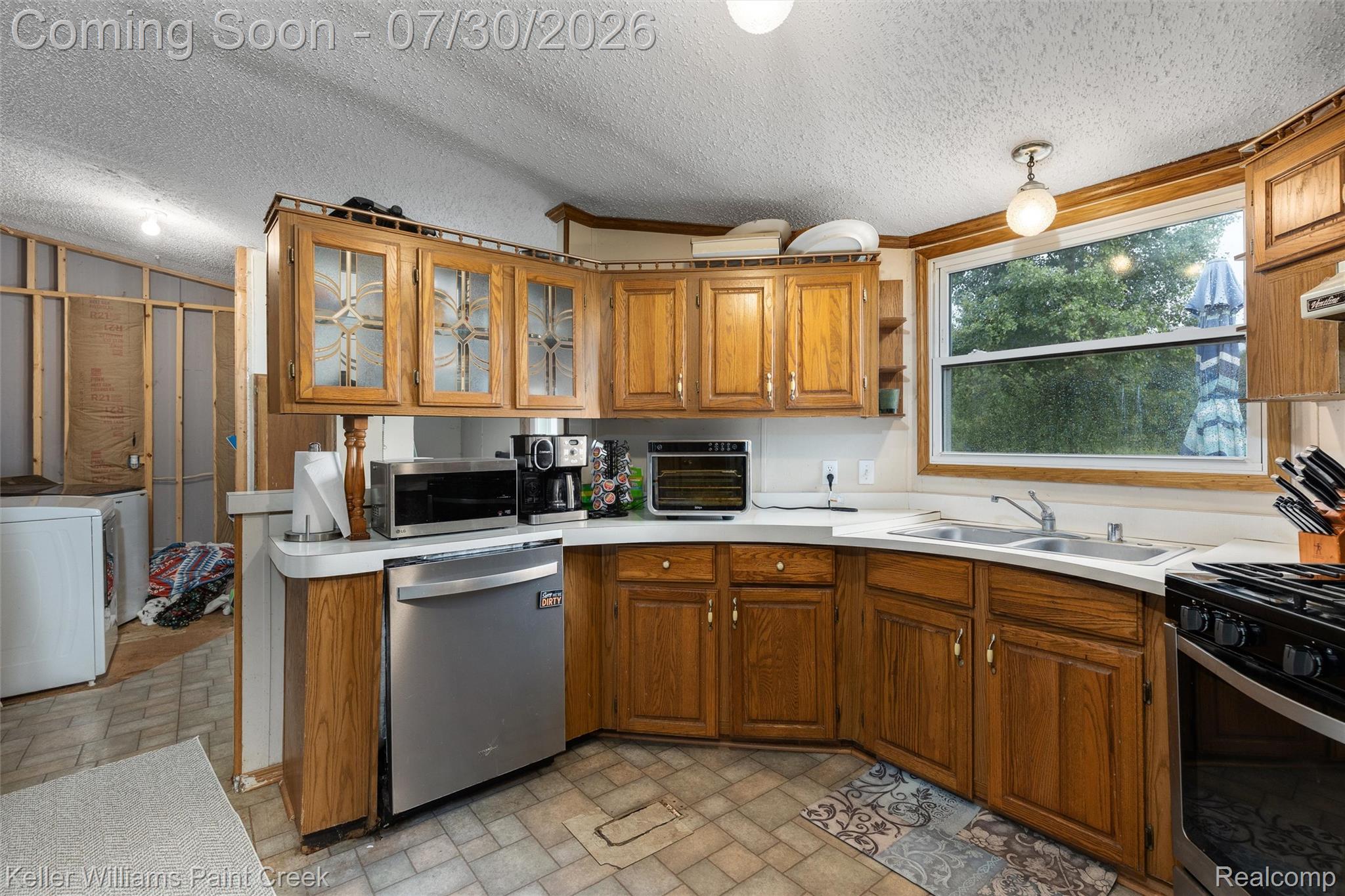 7544 Ravenswood Road Goodells, MI 48027 - Photo 2 of 42 Kitchen featuring wood-finish cabinetry, white countertops, a double basin sink, and a black range
