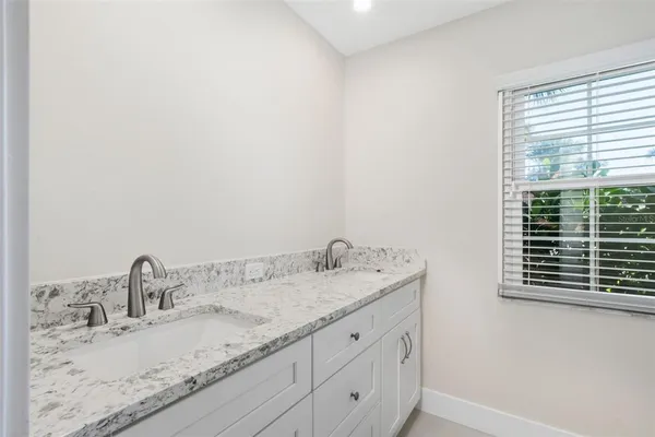 a kitchen with stainless steel appliances granite countertop a refrigerator a stove a sink dishwasher a refrigerator and a dining table with wooden floor