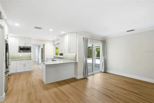 an empty room with wooden floor and closet area