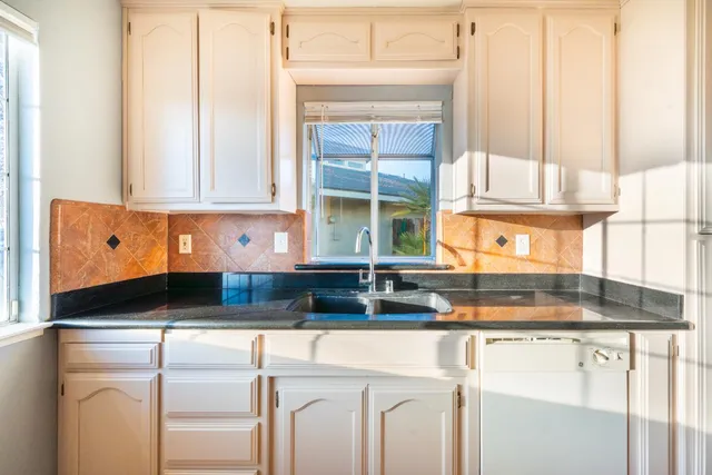 a kitchen with granite countertop a sink and a window