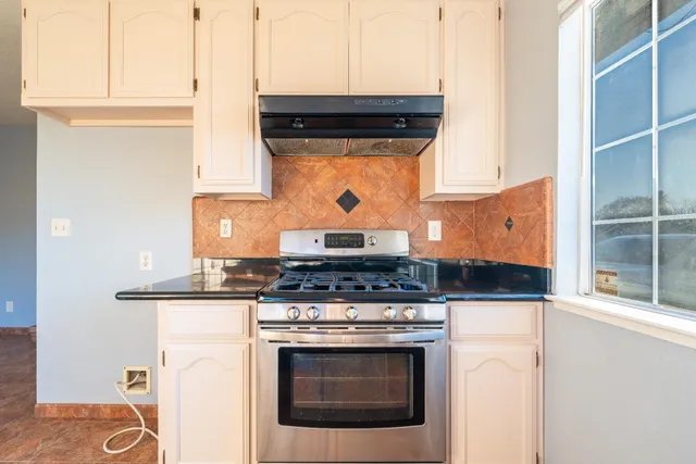 a stove top oven sitting inside of a kitchen