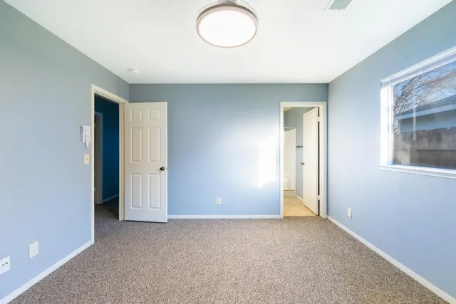an empty room with closet and windows