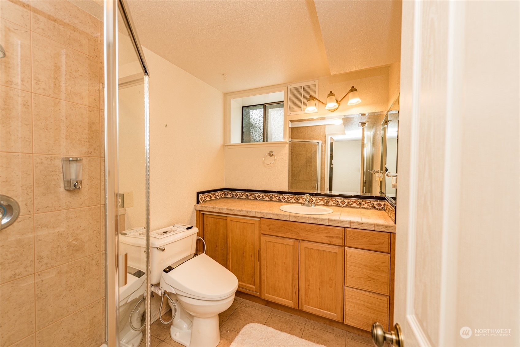 653 Brigadoon Boulevard Sequim, WA 98382 - Photo 30 of 40 a bathroom with a granite countertop toilet sink and mirror
