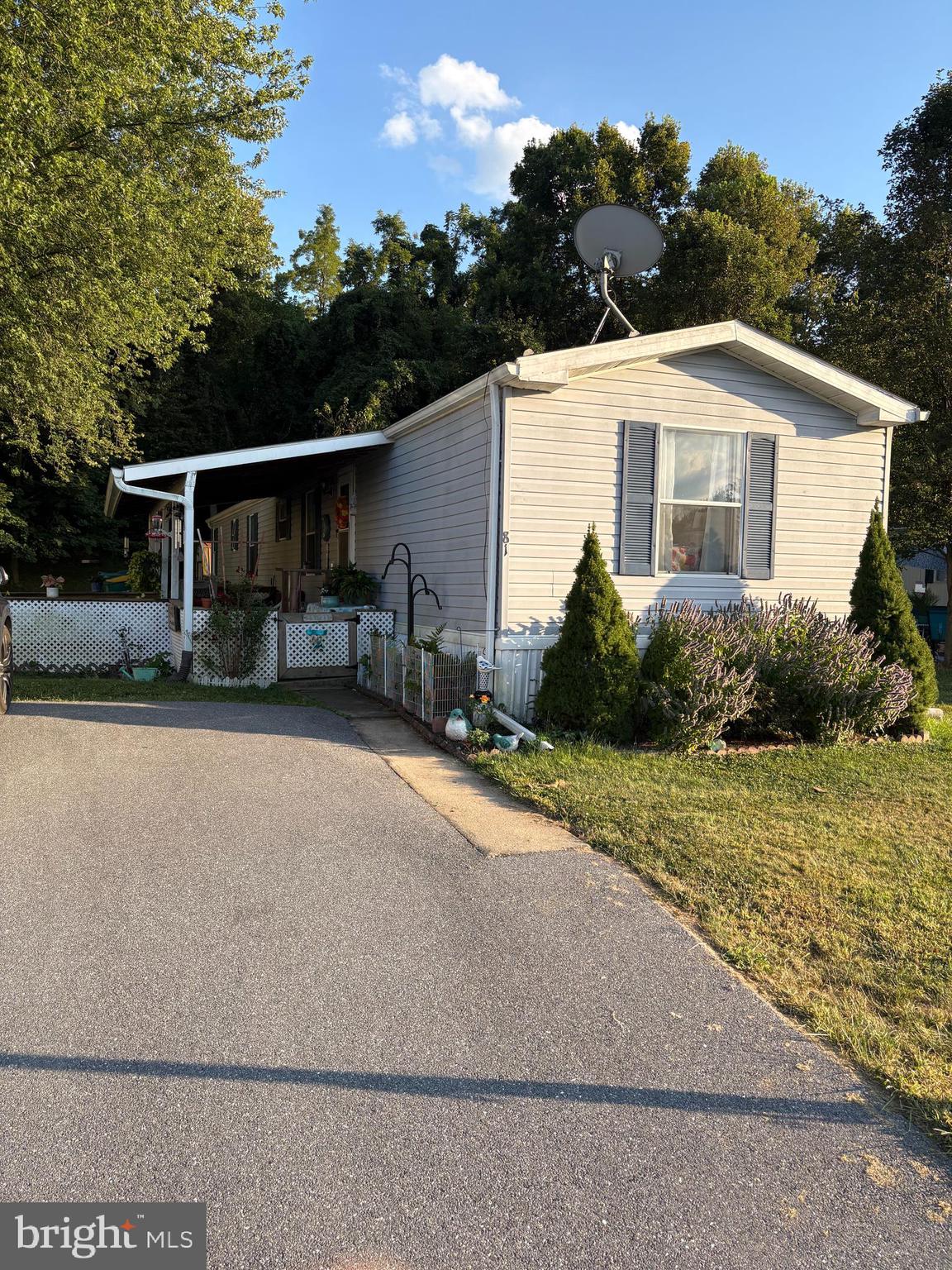 a front view of house with yard and trees in the background