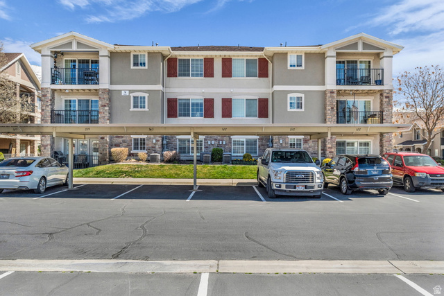 View of apartment building / complex with covered parking