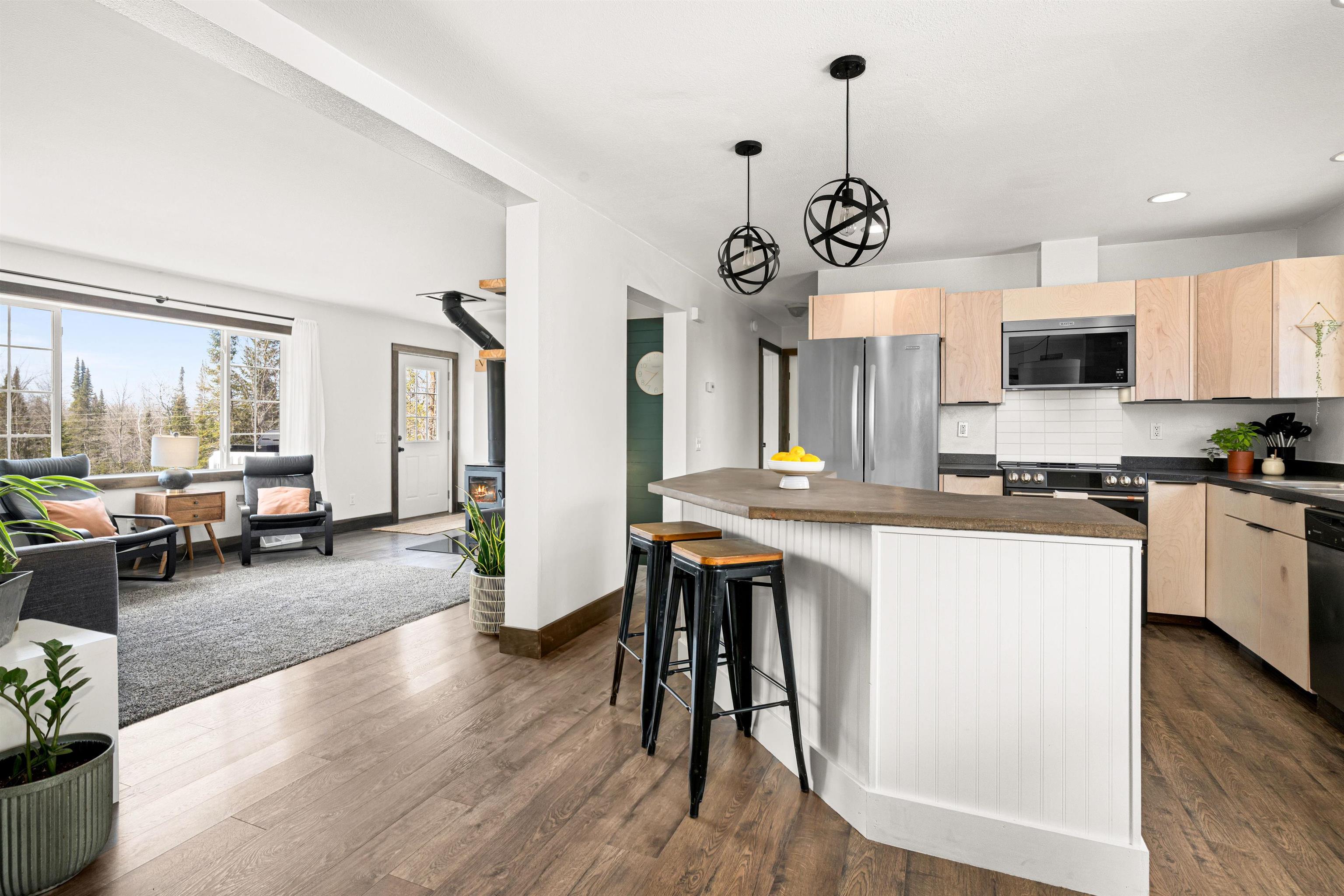 7422 Industrial Road Saginaw, MN 55779 - Photo 33 of 33 Kitchen with tasteful backsplash & cabinets, open floor plan, dark countertops, and stainless steel appliances & Island.