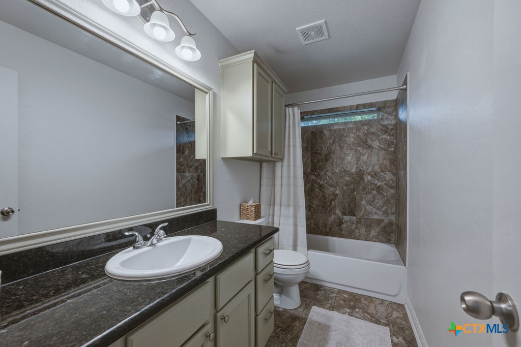 3306 Spring Canyon Road Belton, TX 76513 - Photo 31 of 40 a bathroom with a sink a toilet a mirror a bathtub and shower