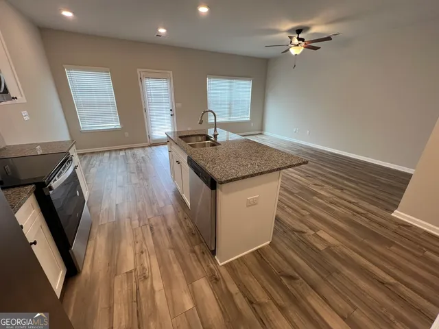 a kitchen with a sink and wooden floor