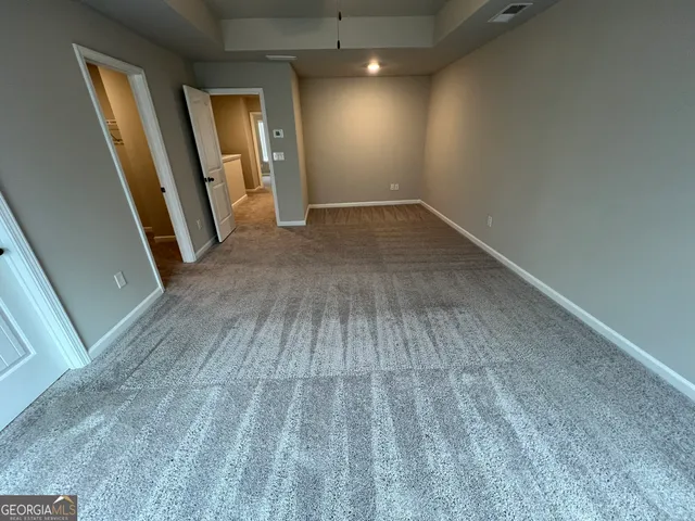 an empty room with wooden floor and entrance