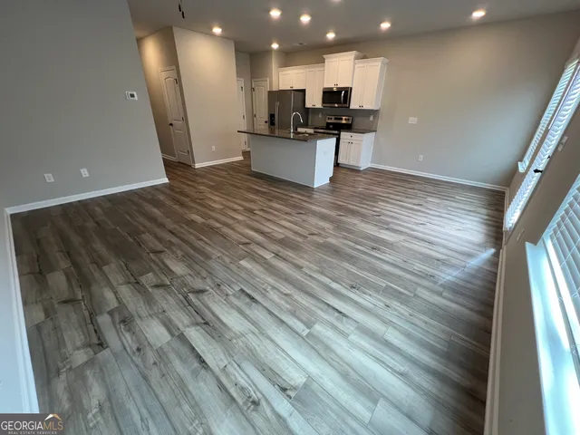 a view of kitchen with kitchen island white cabinets and black appliances