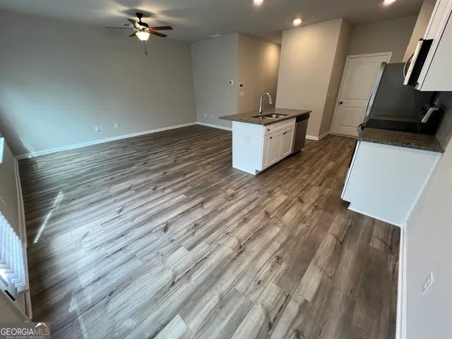 a view of a kitchen with flat screen tv and wooden floor